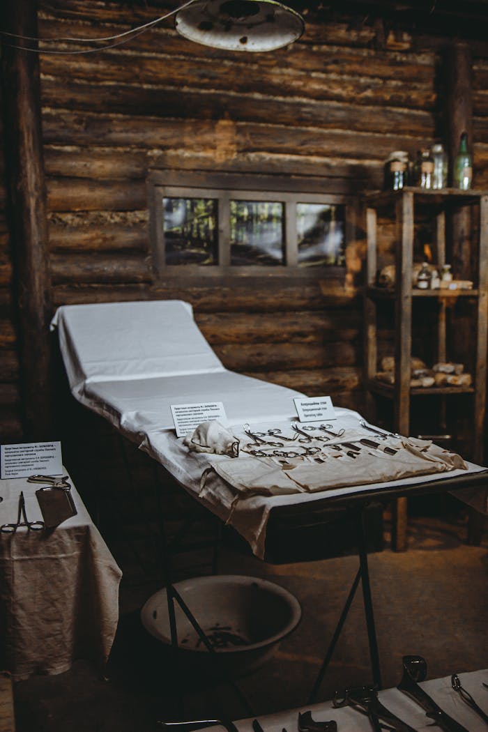 Rustic medical examination room with bed and antique tools for a vintage look.