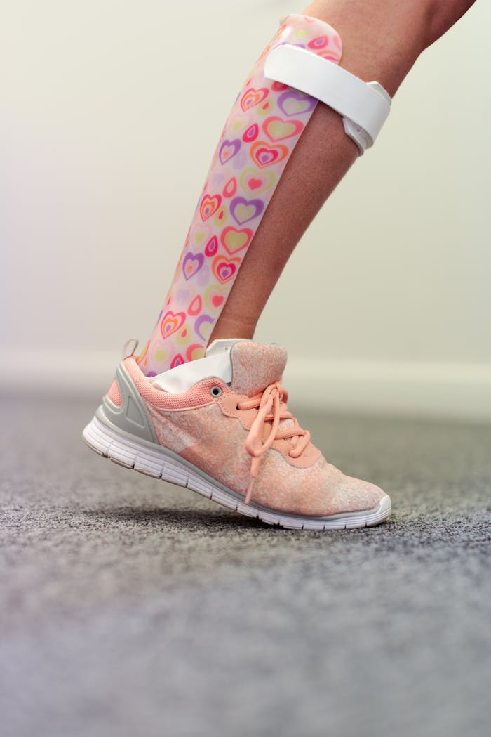 Close-up of an ankle foot orthosis with a playful design on a childs leg wearing a sneaker.